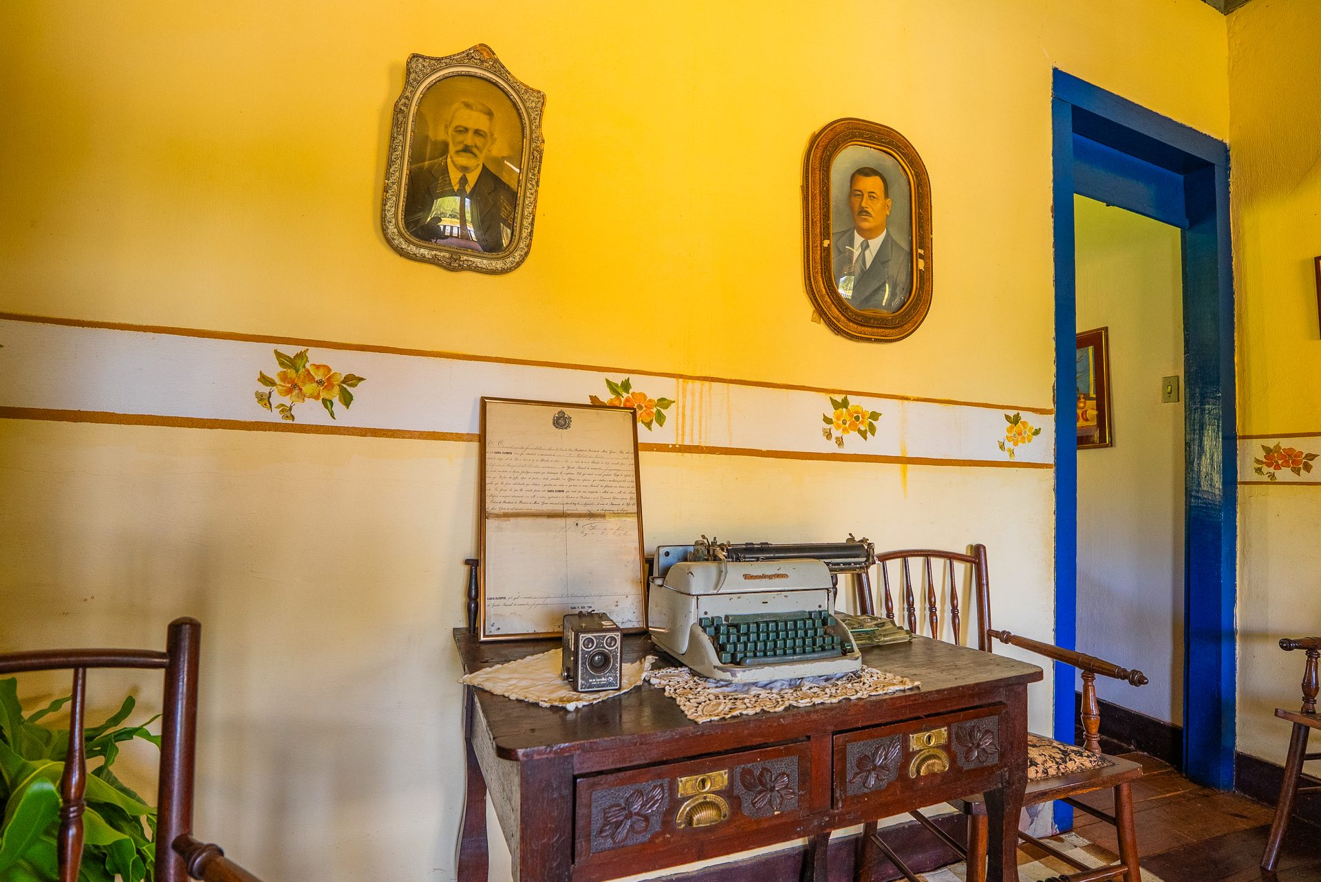 Interior do casarão com retratos antigos, máquina de escrever e escritura original